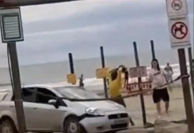 Casal invade praia de carro, é atacado a pedradas e tenta atropelar agressor