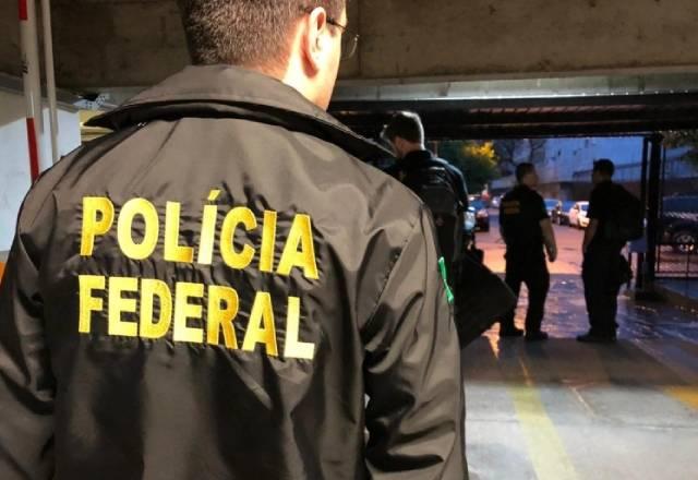 agente da PF de costas com casaco da instituição