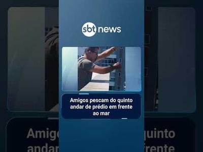 Amigos pescam do quinto andar de prédio em frente ao mar