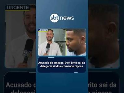 Acusado de ameaça, Davi Brito sai da delegacia rindo e comendo pipoca