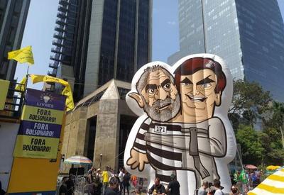 Bonecos de Lula e Bolsonaro entrelaçados são vistos em ato neste domingo