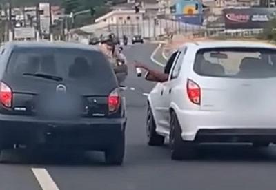 Flagrante: motoristas de carros diferentes trocam bebidas em rodovia