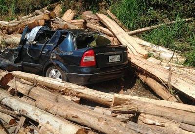 Motorista morre após carga de toras de madeira cair sobre carro
