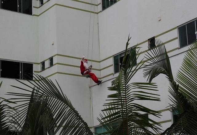 Homem vestido de Papai Noel desce prédio de hospital de rapel