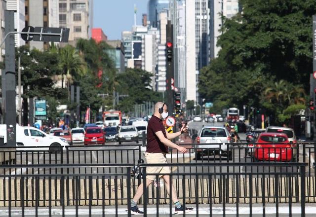 Homem olha para tela do celular enquanto caminha (Rovena Rosa/Agência Brasil)