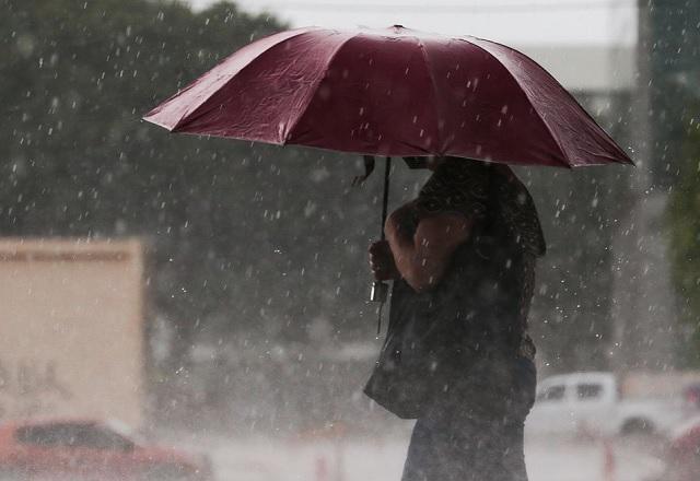 Mulher se protege da chuva com guarda-chuva (Marcello Casal Jr./Agência Brasil)