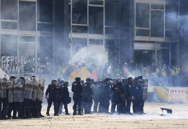 Agentes em meio à fumaça em frente a sede de Poder invadida (Marcelo Camargo/Agência Brasil)