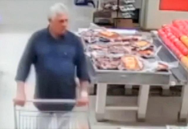 Homem branco, de cabelos grisalhos, empurrando carrinho dentro de corredor de supermercado