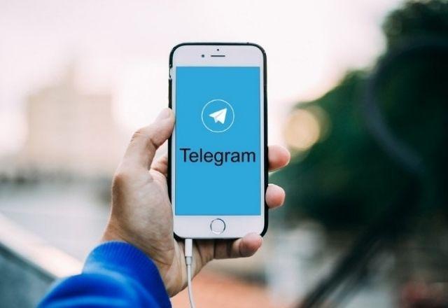 pessoa segurando celular com o aplicativo telegram