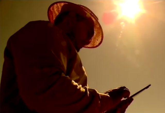 trabalhador do campo usando tablet embaixo do sol forte